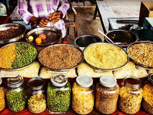 Colorful display of spices and legumes in a traditional Indian street market.