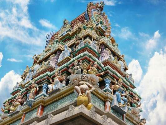 Vibrant gopuram of a Hindu temple in Salem, India, showcasing intricate designs under a blue sky.