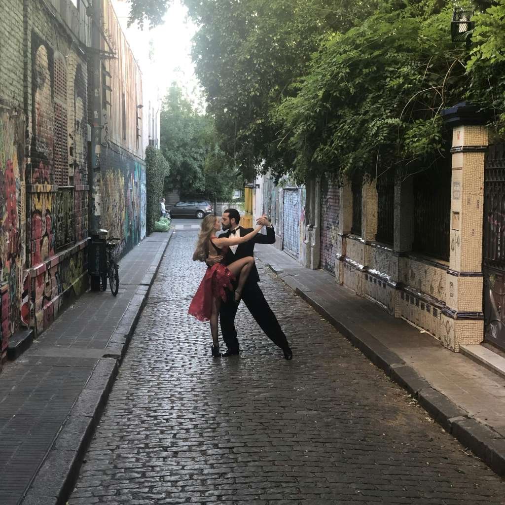 A couple dancing tango on a colorful cobblestone street in Palermo, Buenos Aires.